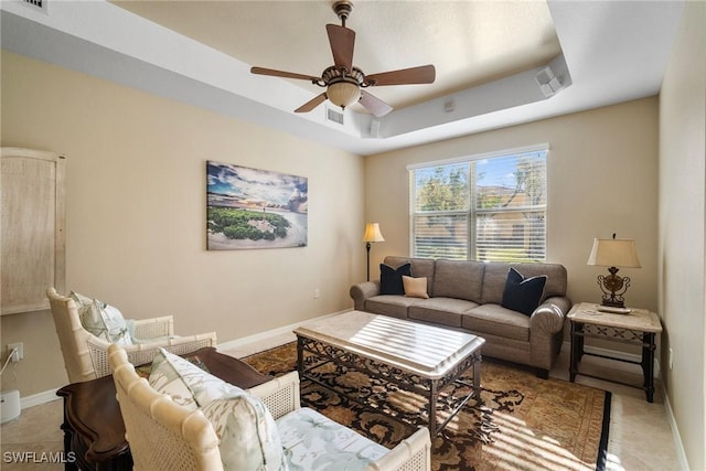 living room featuring a raised ceiling and ceiling fan