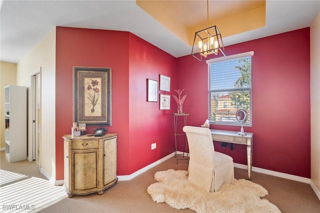 office featuring a raised ceiling, carpet flooring, and a notable chandelier