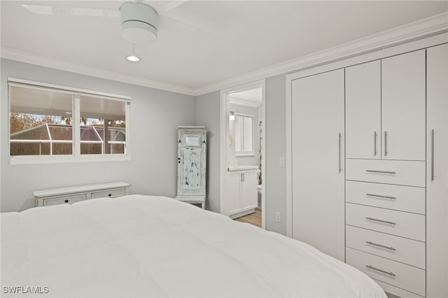 bedroom with crown molding, ceiling fan, a closet, and ensuite bath