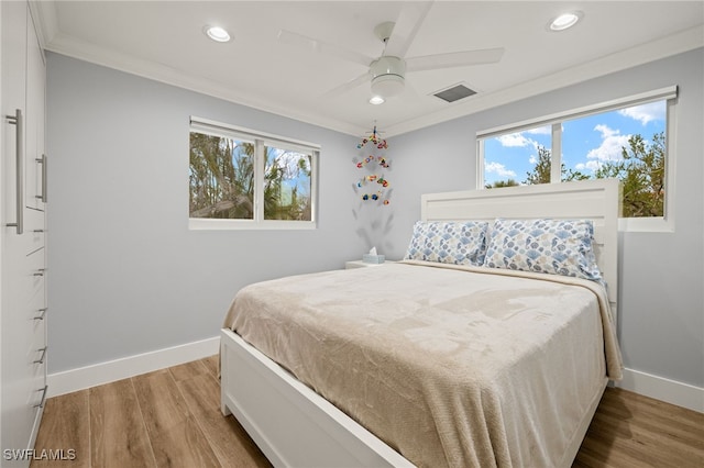 bedroom featuring crown molding, ceiling fan, and light hardwood / wood-style floors