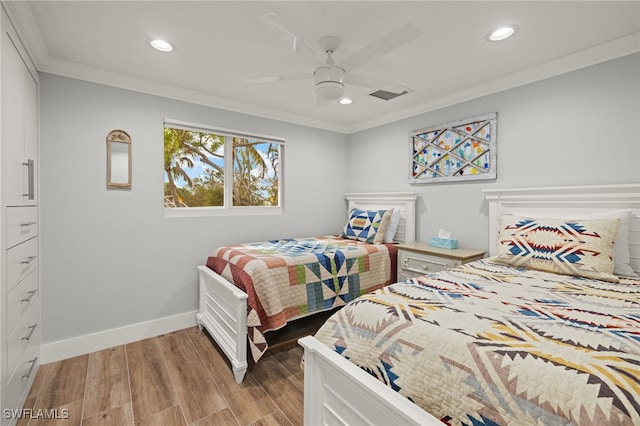 bedroom with crown molding, light hardwood / wood-style floors, and ceiling fan