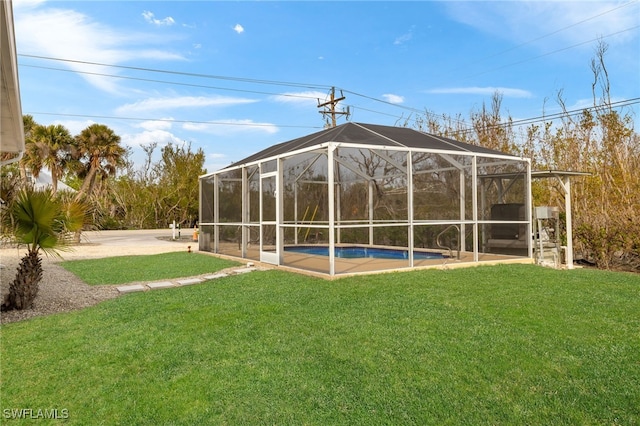 rear view of house with glass enclosure and a lawn