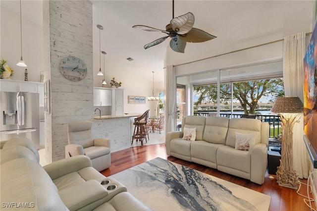 living room featuring dark wood-type flooring, ceiling fan, and wooden walls