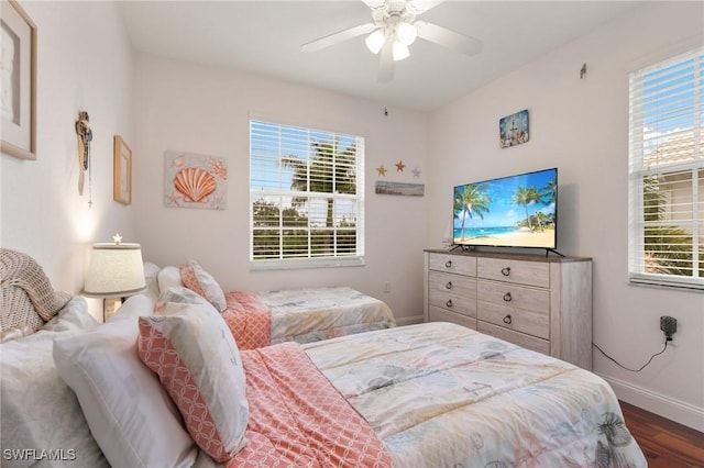 bedroom with dark wood-type flooring, ceiling fan, and multiple windows