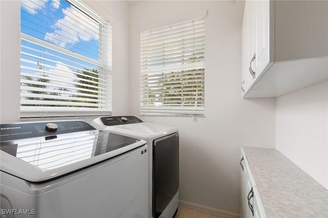 laundry area with cabinets and washer and clothes dryer