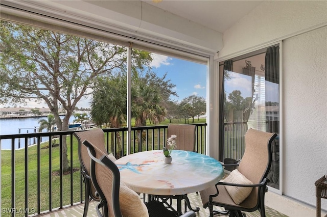 sunroom / solarium featuring a water view