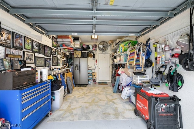 garage featuring stainless steel refrigerator with ice dispenser