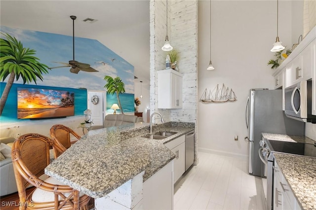 kitchen featuring sink, a breakfast bar area, white cabinets, and appliances with stainless steel finishes