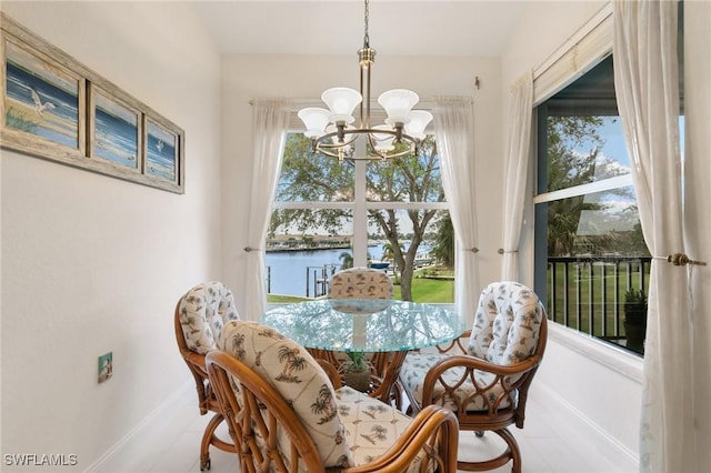 dining area with a water view and an inviting chandelier