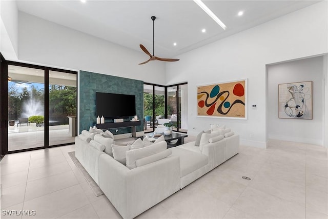 living room with a towering ceiling and ceiling fan