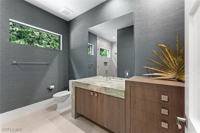 bathroom with tile patterned flooring, vanity, a wealth of natural light, and toilet