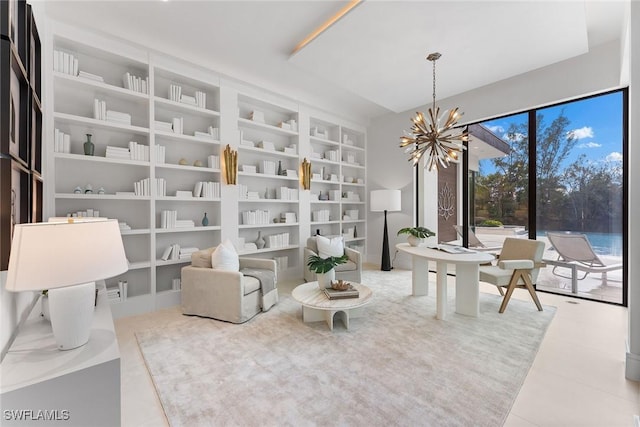 sitting room with a water view, an inviting chandelier, and built in shelves