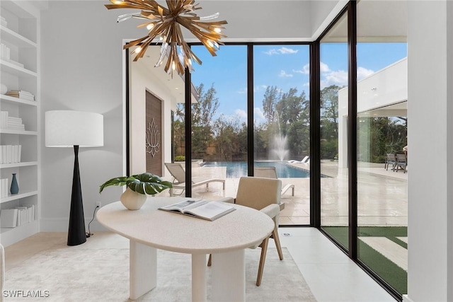 sunroom with a water view, a wealth of natural light, and an inviting chandelier