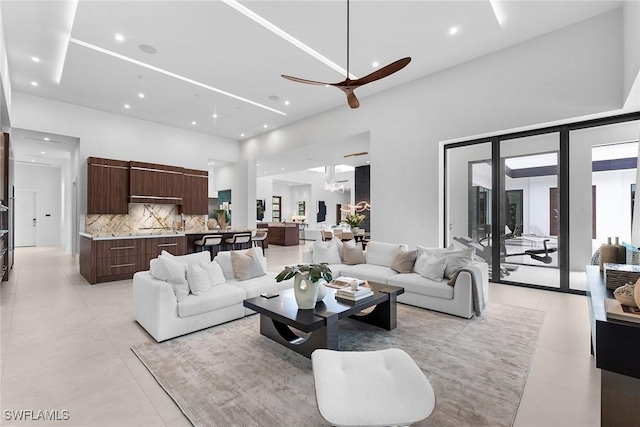 living room featuring light tile patterned flooring, a towering ceiling, and ceiling fan