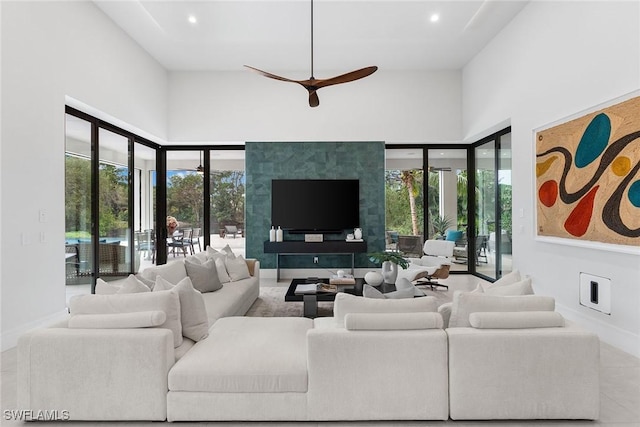 living room featuring ceiling fan and a high ceiling