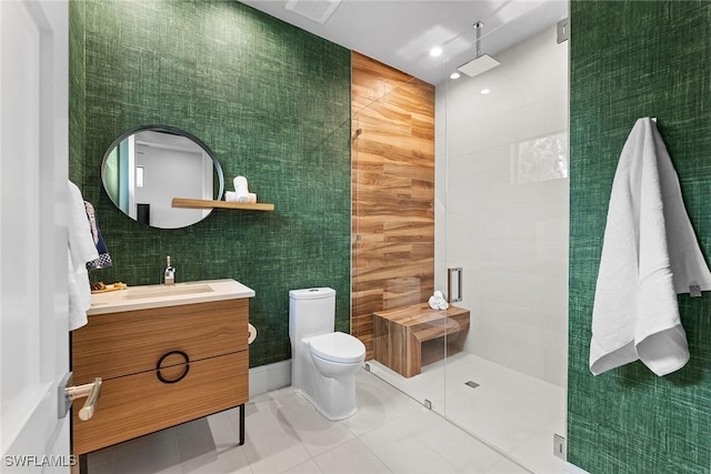 bathroom with tile patterned floors, toilet, tile walls, vanity, and a shower with door