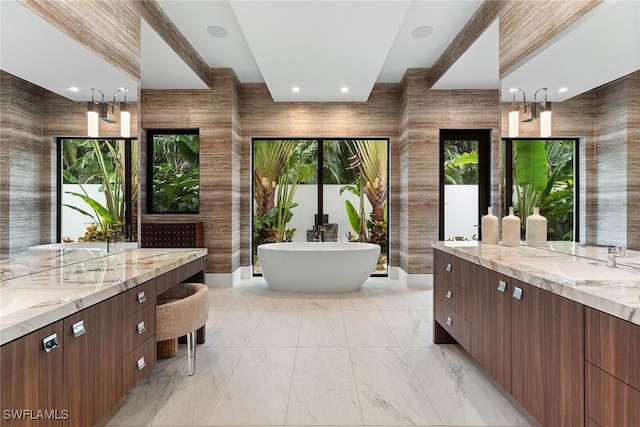 bathroom with tile walls, vanity, and a bathing tub