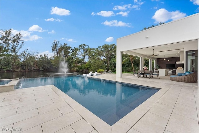 view of pool featuring ceiling fan, a water view, a patio area, area for grilling, and pool water feature