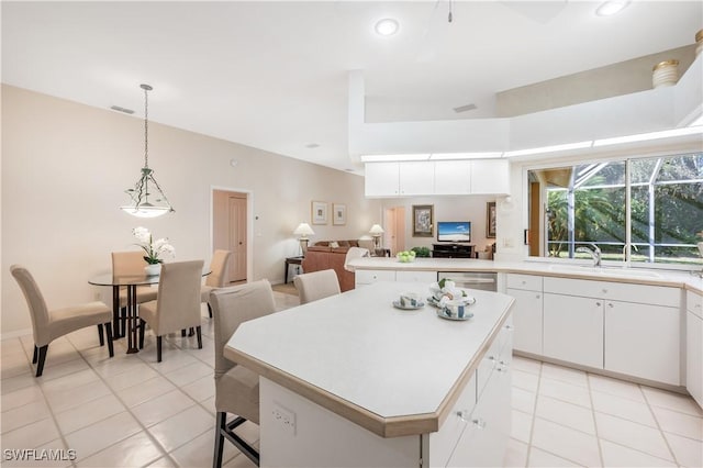 kitchen featuring white cabinetry, a center island, sink, and hanging light fixtures