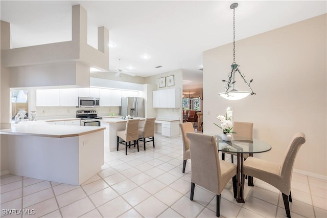 dining space featuring a towering ceiling, sink, and light tile patterned floors