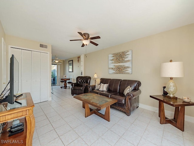 living area with light tile patterned floors, baseboards, visible vents, and a ceiling fan