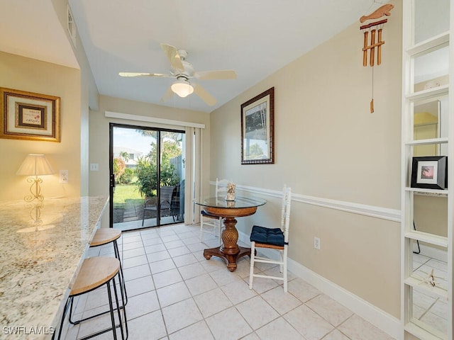 dining space featuring ceiling fan, baseboards, and light tile patterned flooring