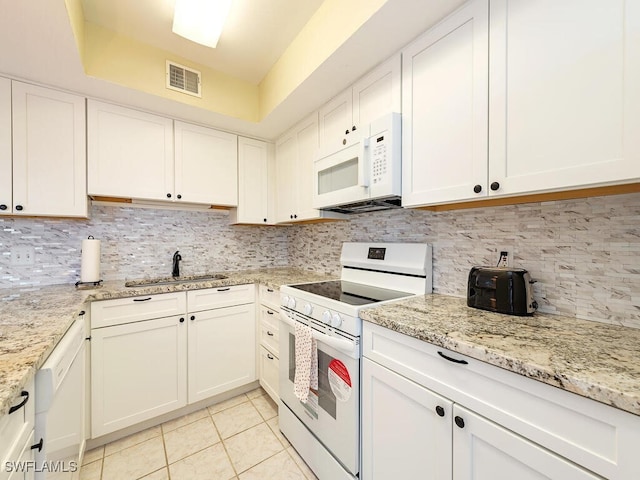 kitchen featuring white appliances, tasteful backsplash, light tile patterned floors, visible vents, and a sink