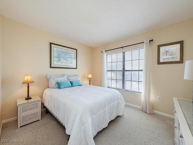 bedroom featuring baseboards, a textured ceiling, and light colored carpet