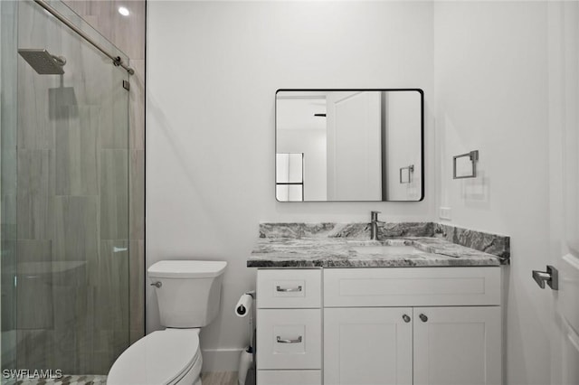 bathroom featuring vanity, an enclosed shower, and toilet