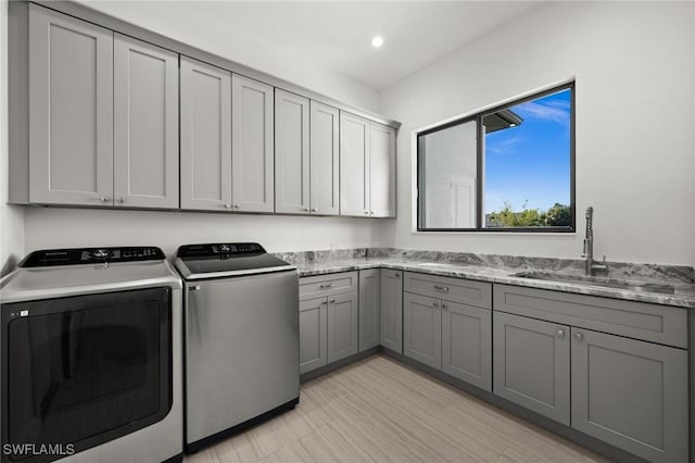 laundry area featuring cabinets, sink, and washing machine and dryer