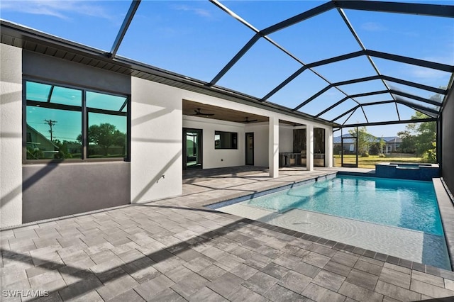 view of swimming pool featuring ceiling fan, an in ground hot tub, glass enclosure, and a patio area