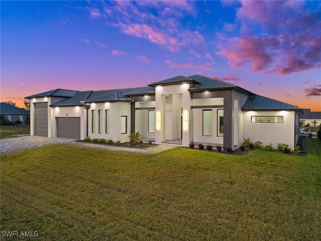 view of front facade featuring a garage and a lawn