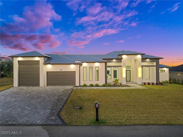 prairie-style home with a garage and a lawn