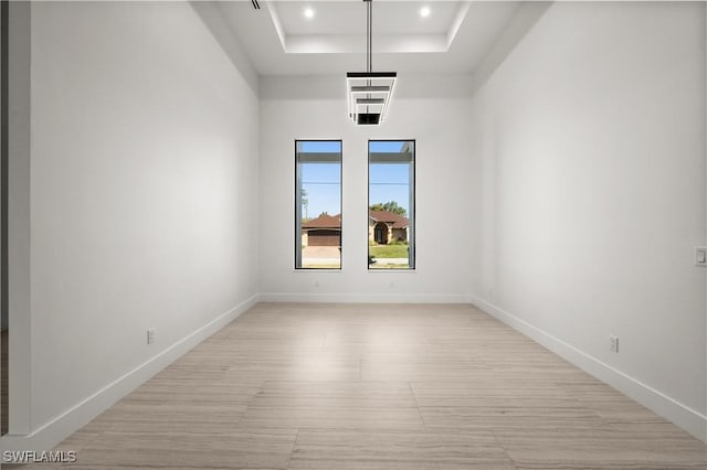 unfurnished room featuring a towering ceiling and a tray ceiling