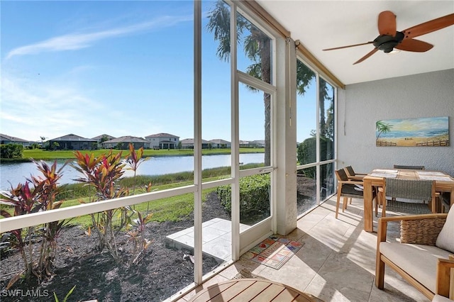 sunroom / solarium with a water view and ceiling fan