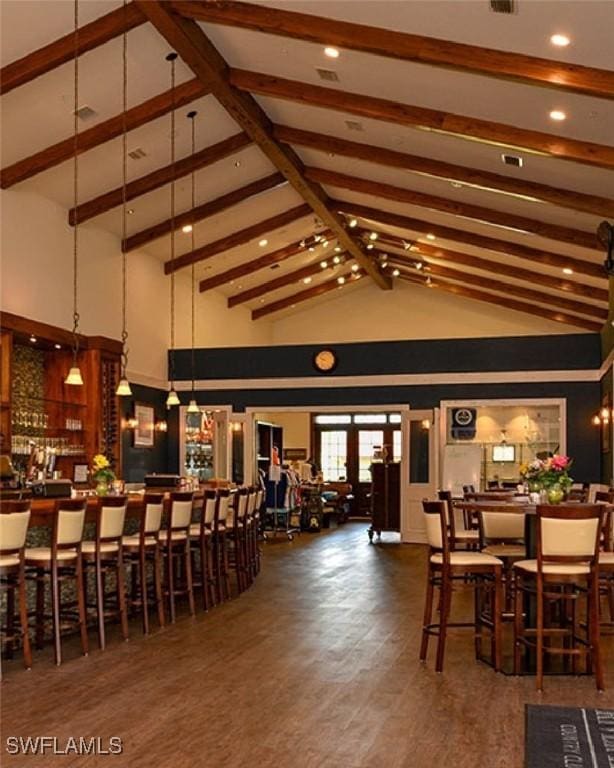 dining room featuring dark wood-type flooring, high vaulted ceiling, and beamed ceiling