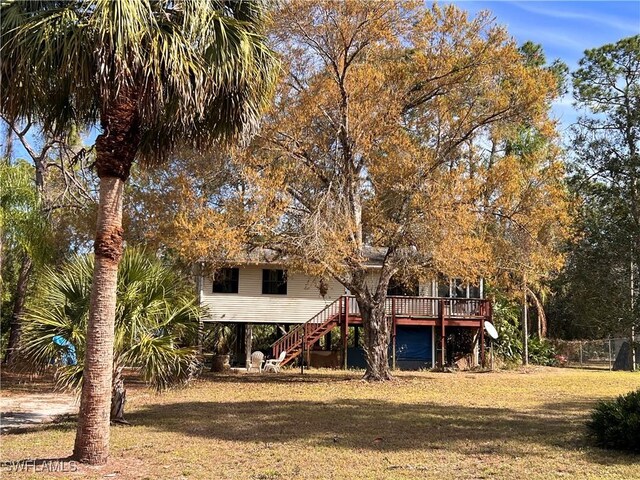 rear view of property with a wooden deck and a lawn