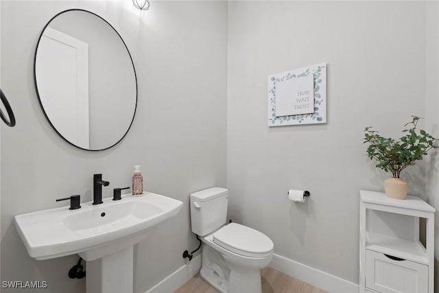 bathroom featuring sink, hardwood / wood-style floors, and toilet