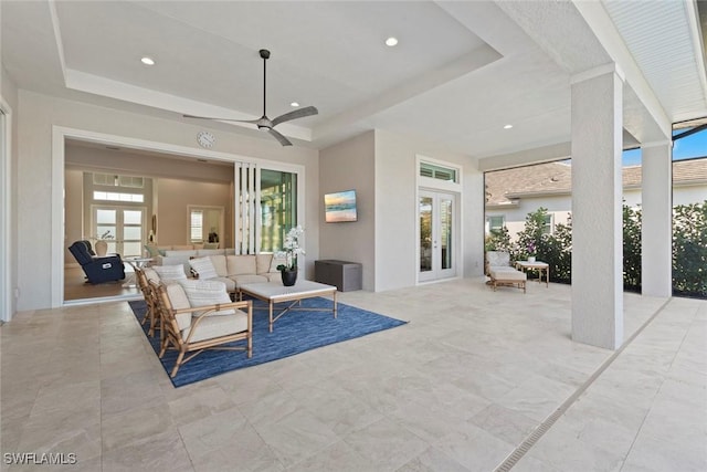 living room with french doors, ceiling fan, and a raised ceiling