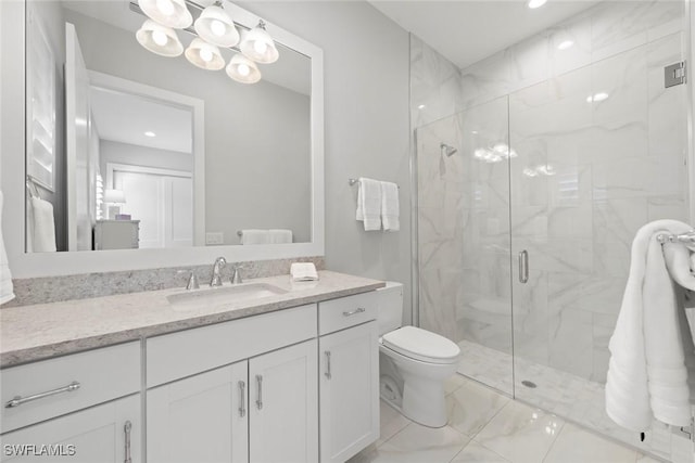 bathroom featuring vanity, a shower with shower door, and toilet