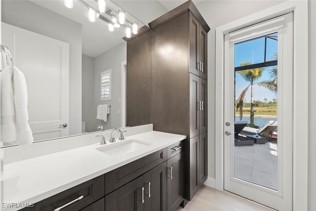 bathroom featuring vanity, plenty of natural light, and toilet