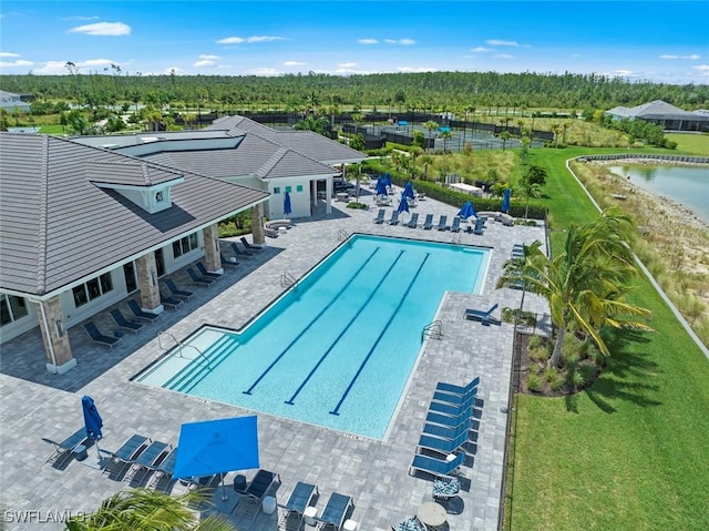 view of swimming pool with a yard, a patio area, and a water view