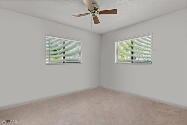 carpeted spare room featuring ceiling fan