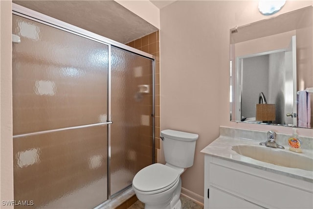 bathroom featuring vanity, toilet, and a shower with door