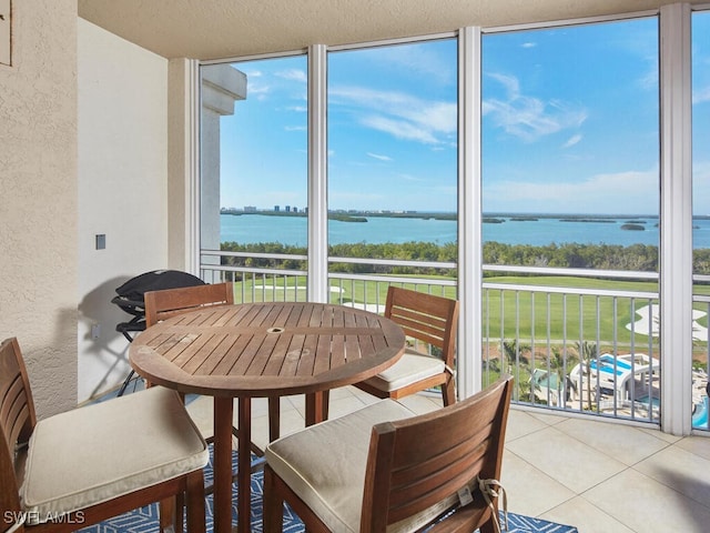 sunroom featuring a water view