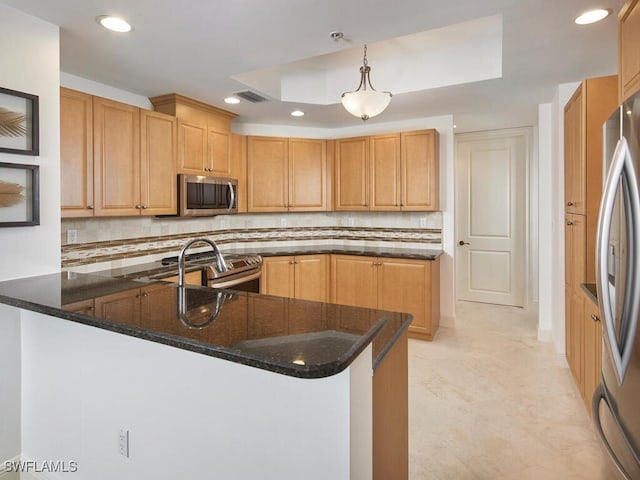 kitchen with hanging light fixtures, stainless steel appliances, dark stone counters, and kitchen peninsula