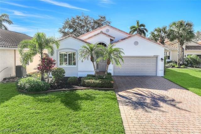 mediterranean / spanish home featuring a garage and a front yard