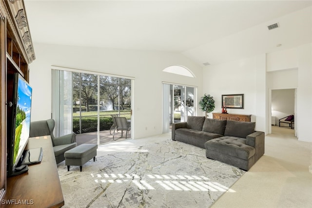 carpeted living room with high vaulted ceiling