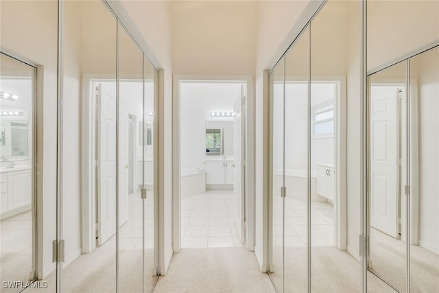 hallway featuring light colored carpet and a high ceiling