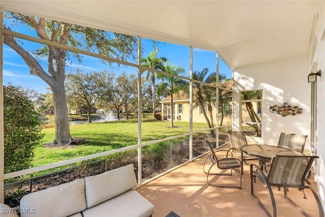 sunroom featuring a water view and vaulted ceiling